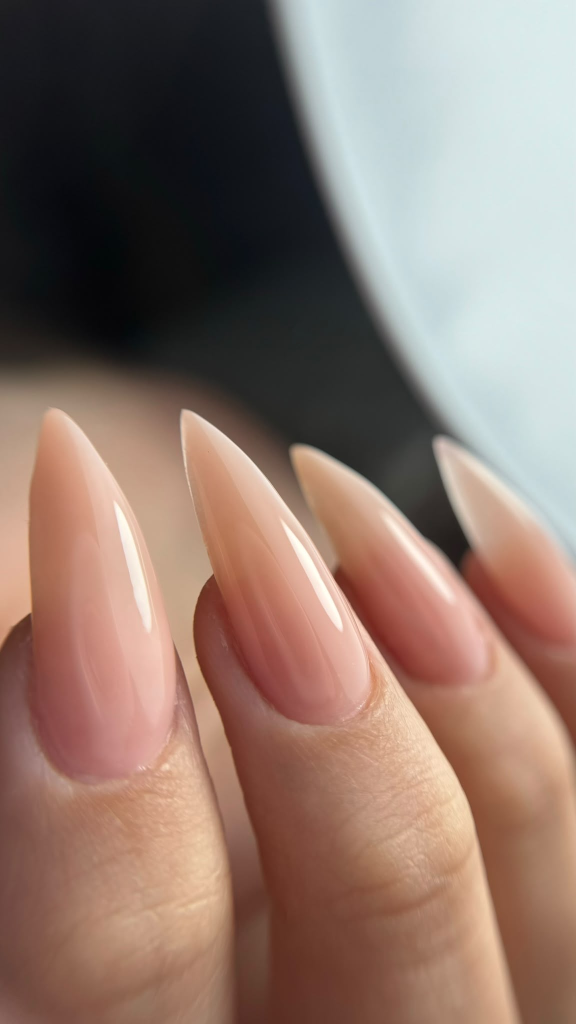 Clean nude almond nails photographed on a client hand
