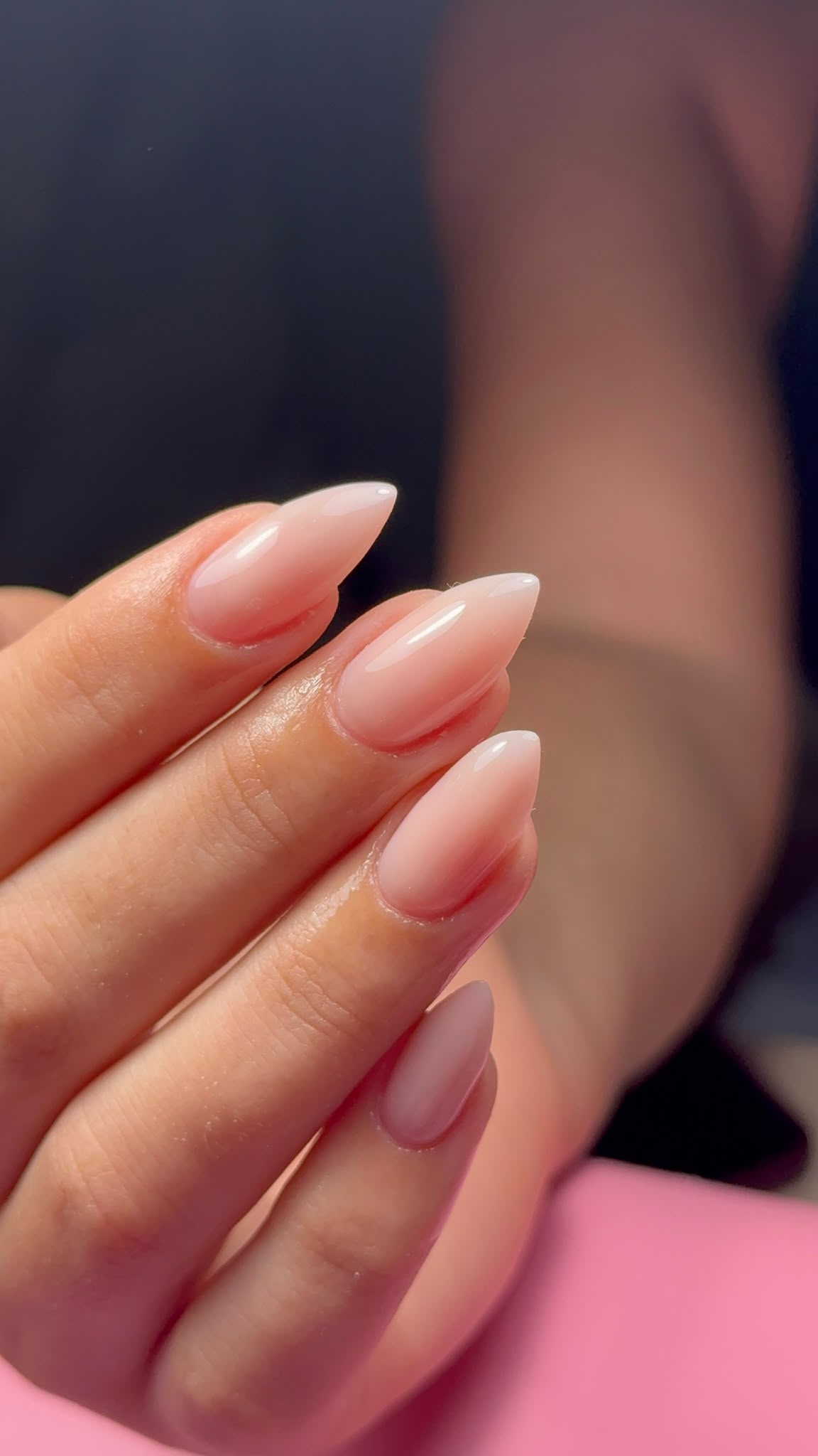 Sheer nude almond nails in a close-up client photo