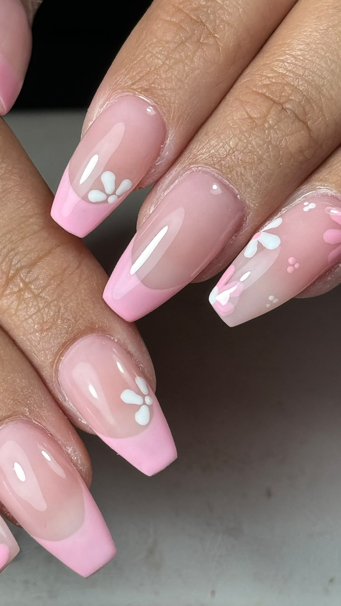 Pink French nails with white floral details
