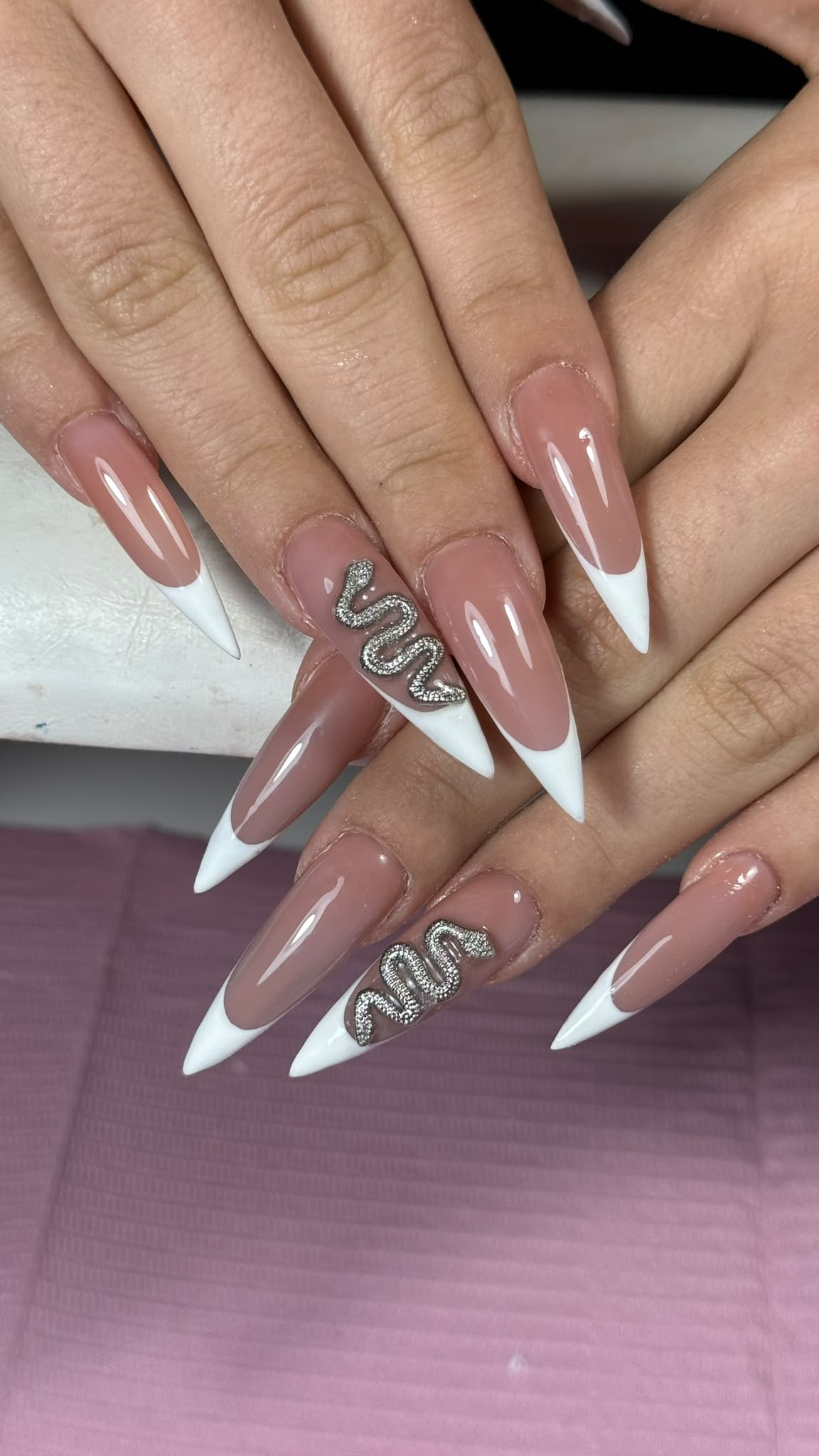 White French nails with a silver snake design