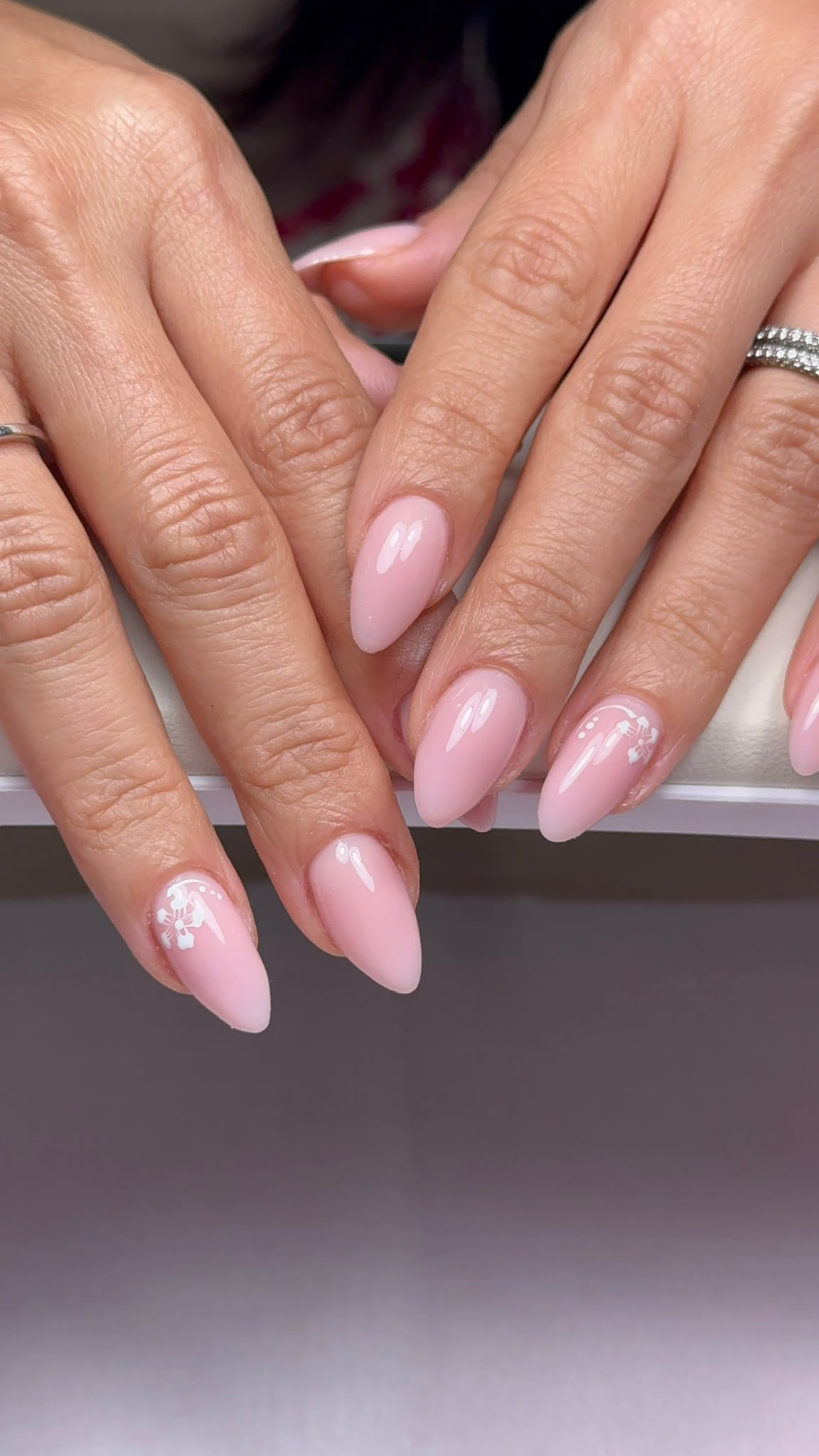 Pink almond nails with white floral details