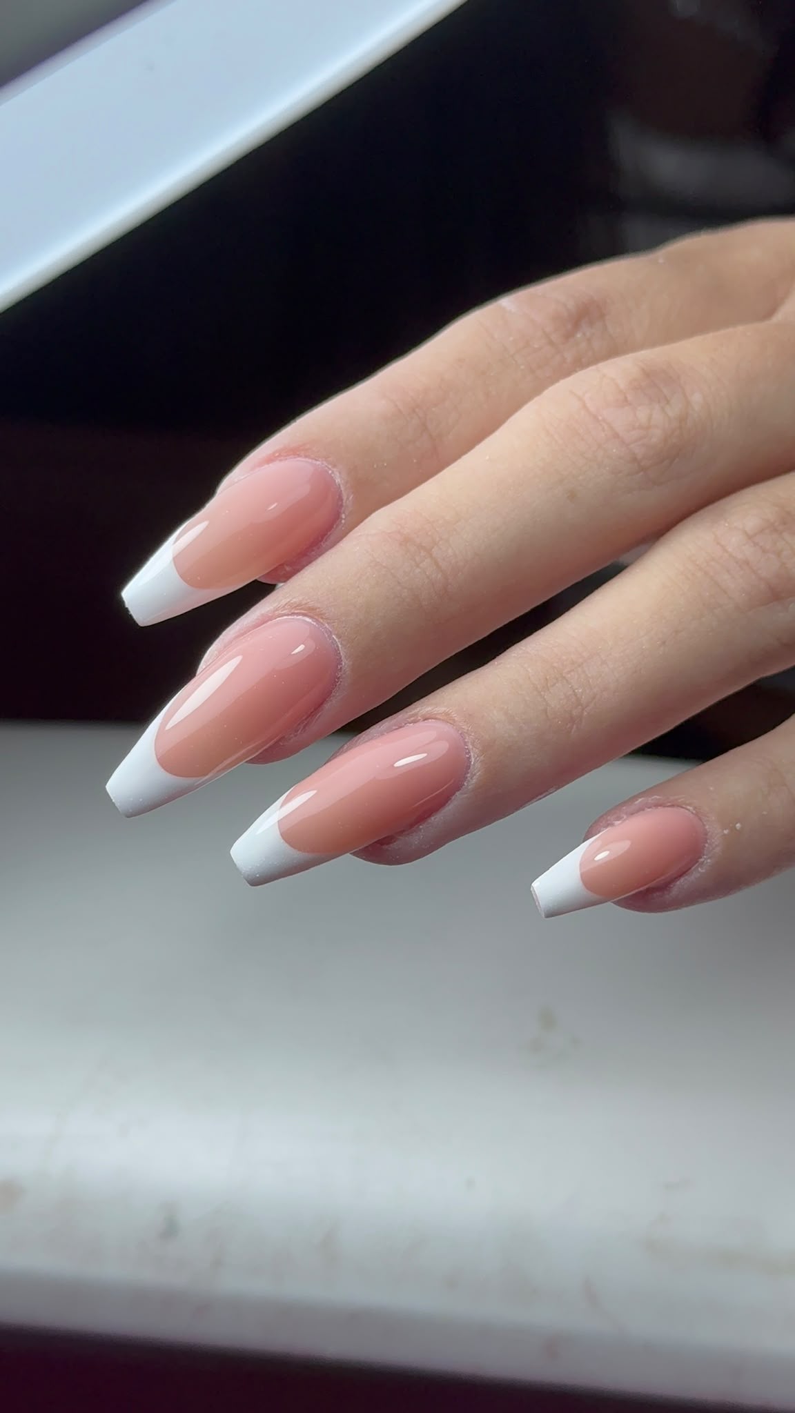 Long white French nails in a client close-up